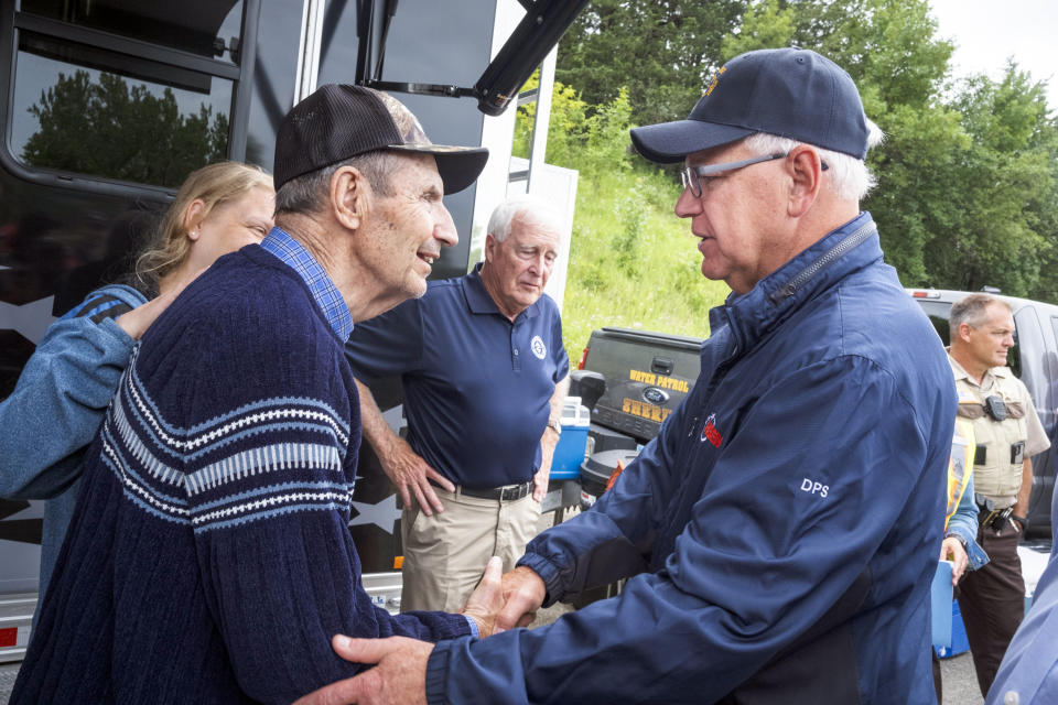 Minnesota Gov. Tim Walz shakes hands with Jim Hruska, whose house fell into the Blue Earth River and whose family owned the recently demolished Dam Store for over 50 years, on Tuesday, July 2, 2024, in Rapidan, Minn., during a visit to the Rapidan Dam site where river waters that diverted the dam have torn through the landscape. (Casey Ek/The Free Press via AP)