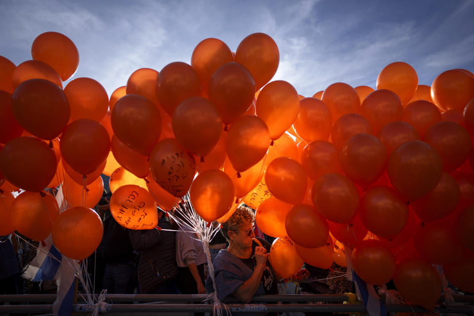 Demonstrators hold orange balloons at a rally in solidarity with Kfir Bibas, an Israeli boy who spent his first birthday Thursday in Hamas captivity in the Gaza Strip, in Tel Aviv, Israel, Thursday, Jan. 18, 2024. The plight of Bibas, the youngest hostage held by Hamas, has captured the nation's attention and drawn attention to the government's failure to bring home more than 100 hostages still held by Hamas after more than three months of war. (AP Photo/Oded Balilty)