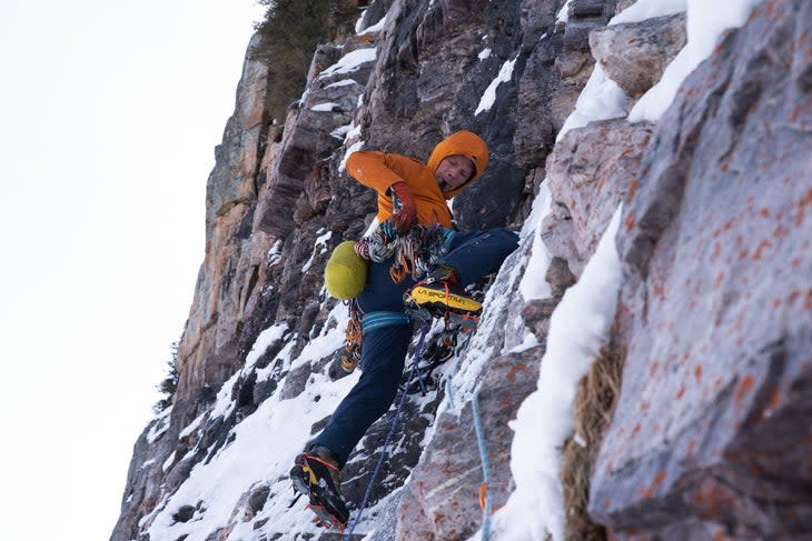 Mixed climbed sorts through gear on their harness.