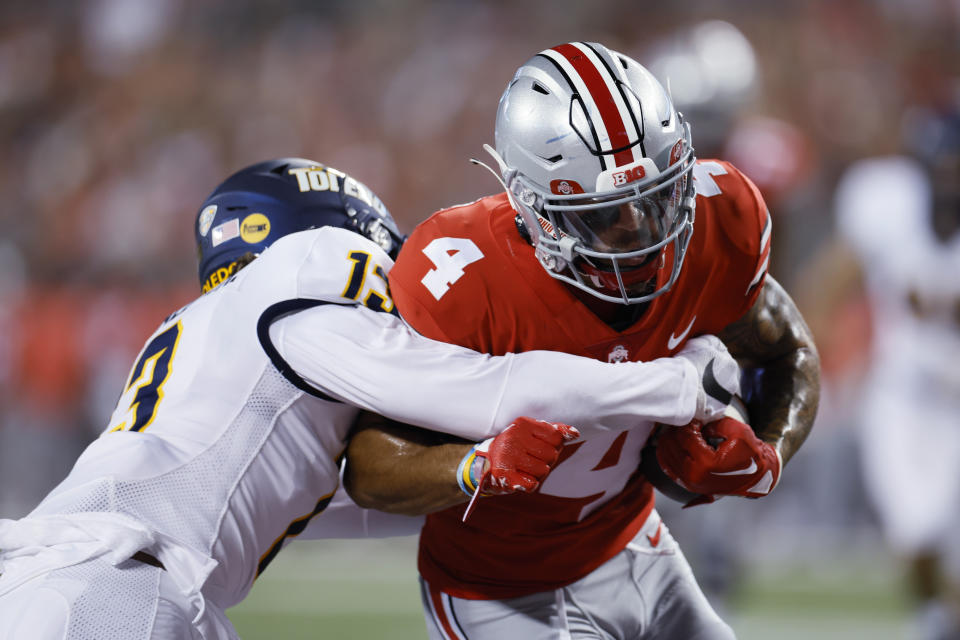 Ohio State receiver Julian Fleming, right, runs past Toledo defensive back Chris McDonald on his way to a touchdown during the first half of an NCAA college football game Saturday, Sept. 17, 2022, in Columbus, Ohio. (AP Photo/Jay LaPrete)