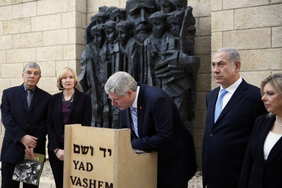 Canada's PM Harper signs the guest book at the Yad Vashem Holocaust Memorial museum in Jerusalem