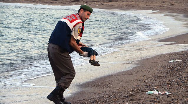 A police officer carries the dead migrant child after he washed up on a beach near the Turkish resort of Bodrum. Photo: AP