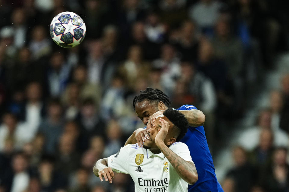 Real Madrid's Eder Militao, bottom, goes for a header with Chelsea's Raheem Sterling during the Champions League quarter final first leg soccer match between Real Madrid and Chelsea at Santiago Bernabeu stadium in Madrid, Wednesday, April 12, 2023. (AP Photo/Jose Breton)