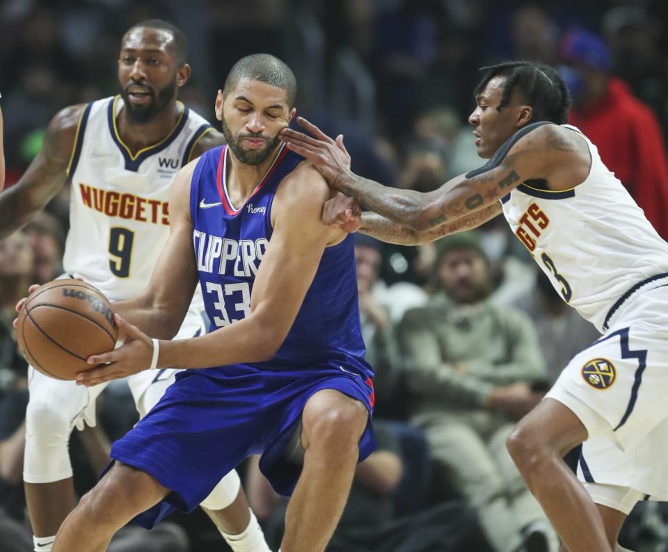 Clippers forward Nicolas Batum power his way to the basket against Nuggets guard Bones Hyland.