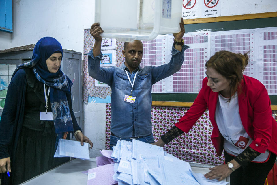 Election officials start counting marked ballots after polling stations closed during a parliamentary election in Tunis, Tunisia, Sunday, Oct. 6, 2019. Tunisians were electing a new parliament Sunday amid a tumultuous political season, with a moderate Islamist party and a jailed tycoon's populist movement vying to come out on top of a crowded field. (AP Photo/Riadh Dridi)