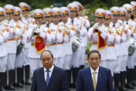 Japanese Prime Minister Yoshihide Suga, right, and his Vietnamese counterpart Nguyen Xuan Phuc, left, attend a welcoming ceremony at the Presidential Palace in Hanoi, Vietnam Monday, Oct. 19, 2020. (Kham/Pool Photo via AP)