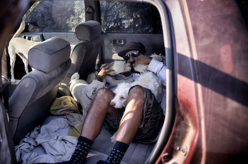 David Clarke who is suffering homelessness and living in his car with his 6 dogs, takes to the shade at the Sepulveda Basin dog park in Los Angeles on Tuesday, July 9, 2024. Dozens of locations in the West and Pacific Northwest tied or broke previous heat records over the weekend and are expected to keep doing so into the week. (AP Photo/Richard Vogel)