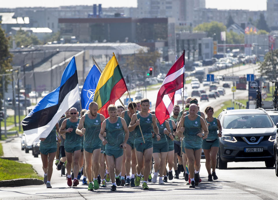 Lithuanian people take part in a traditional relay race Vilnius-Riga-Tallinn dedicated to the 30th anniversary of the Baltic Way at the Cathedral Square in Vilnius, Lithuania, Friday Aug. 23, 2019. Estonia’s prime minister says one should never forget the 1989 “Baltic Way” in which nearly 2 million people of then-Soviet Lithuania, Latvia and Estonia formed a human chain more than 600 kilometers (370 miles) long to protest Soviet occupation. (AP Photo/Mindaugas Kulbis)