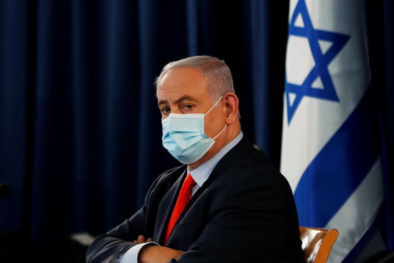 FILE PHOTO: Israeli Prime Minister Benjamin Netanyahu wears a mask as he looks on during the weekly cabinet meeting in Jerusalem