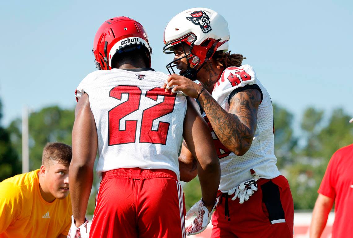 N.C. State’s Devin Carter (88) talks with Micah Crowell (22) about how to do a drill during the Wolfpack’s first practice of fall camp in Raleigh, N.C., Wednesday, August 3, 2022.