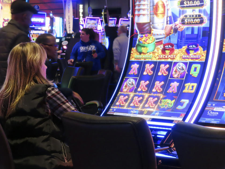 A woman plays a slot machine at the Ocean Casino Resort in Atlantic City, N.J., Dec. 2, 2022. Figures released April 10, 2023, by New Jersey gambling regulators show the city's nine casinos collectively posted a gross operating profit of $731 million in 2022, down 4.6% from the previous year. (AP Photo/Wayne Parry)