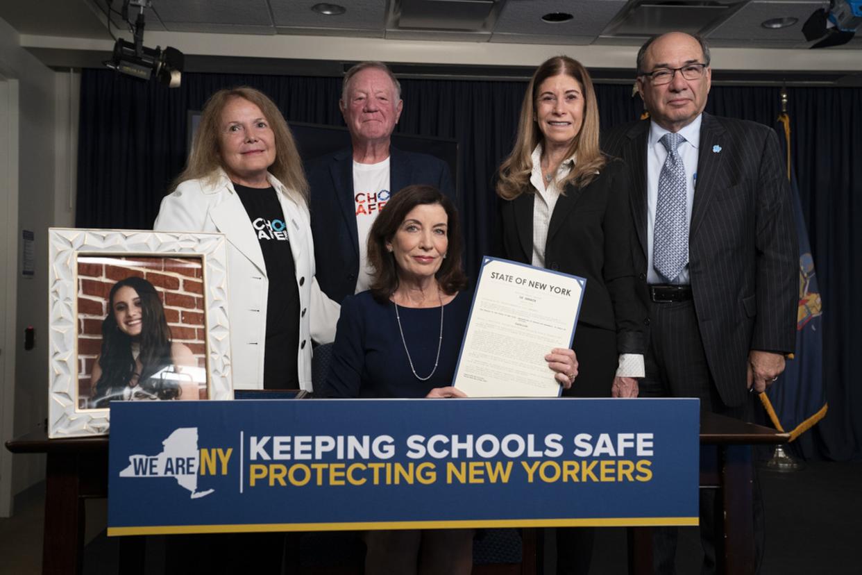 Terri, left, and David Robinovitz and Linda Beigel Schulman and her husband Michael pose with New York Gov. Kathy Hochul after the signing of Alyssa's Law on June 23, 2022 in Manhattan.