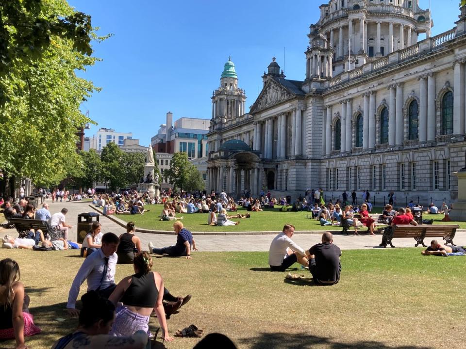 People enjoy an al fresco lunch in the grounds of Belfast City Hall (Rebecca Black/PA) (PA Wire)