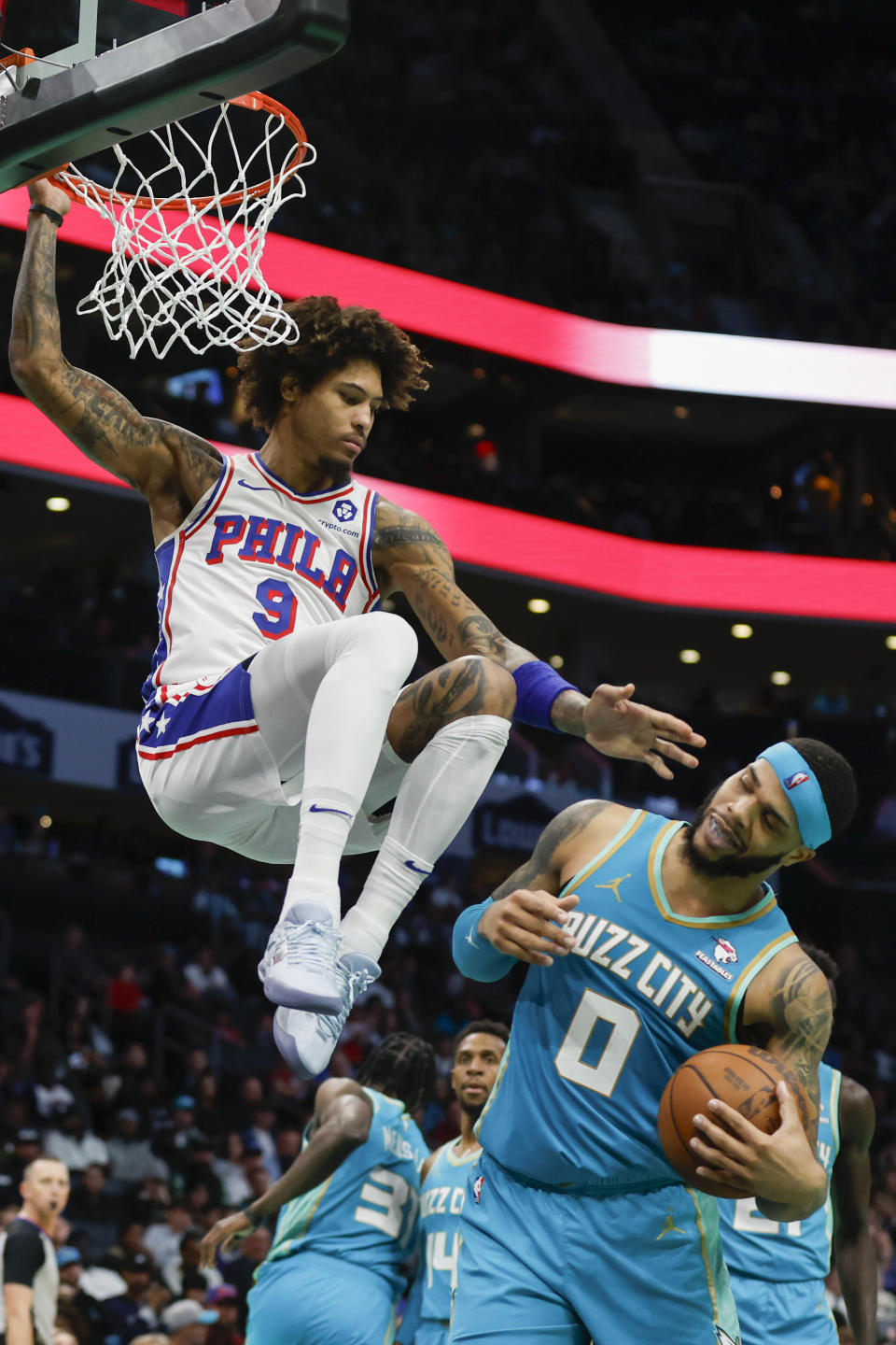 Philadelphia 76ers guard Kelly Oubre Jr. (9) avoids colliding with Charlotte Hornets forward Miles Bridges (0) after a dunk during the second half of an NBA basketball game in Charlotte, N.C., Saturday, Dec. 16, 2023. (AP Photo/Nell Redmond)