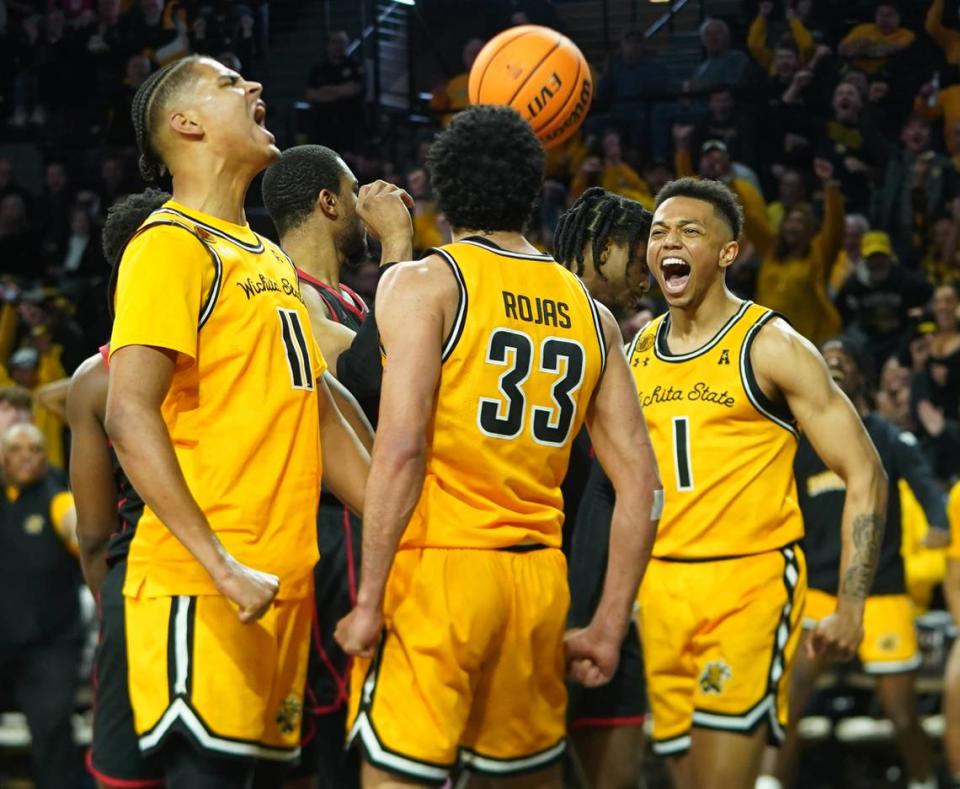 Wichita State University’s Kenny Pohto, left, and James Rojas, center, and Xavier Bell, right, cheer after Rojas was fouled and made a basket against the University of Houston during their game at Koch Arena.