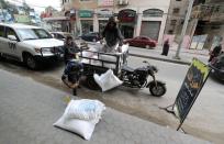 Workers unload food supplies distributed by UNRWA after transporting them to the home of a Palestinian refugee in Gaza City