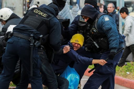 Riot police scuffle with migrants during a demonstration outside the municipal theatre of the city of Mytilene, on the island of Lesbos, on February 4, 2020