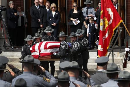 Pennsylvania State Police Troopers carry the casket of slain Pennsylvania State Police Trooper Corporal Bryon Dickson, 38, from St. Peters' Cathedral in Scranton, Pennsylvania September 18, 2014, as his wife Tiffany and son Adam look on, following his funeral service. REUTERS/Mike Segar