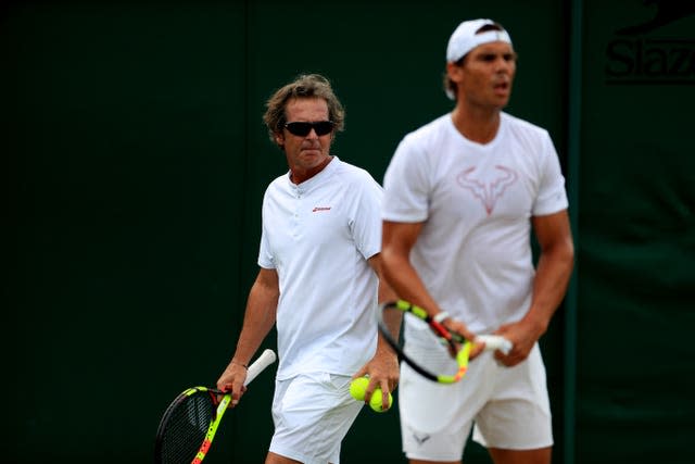 Toni Nadal watches in the background as Rafael Nadal practises