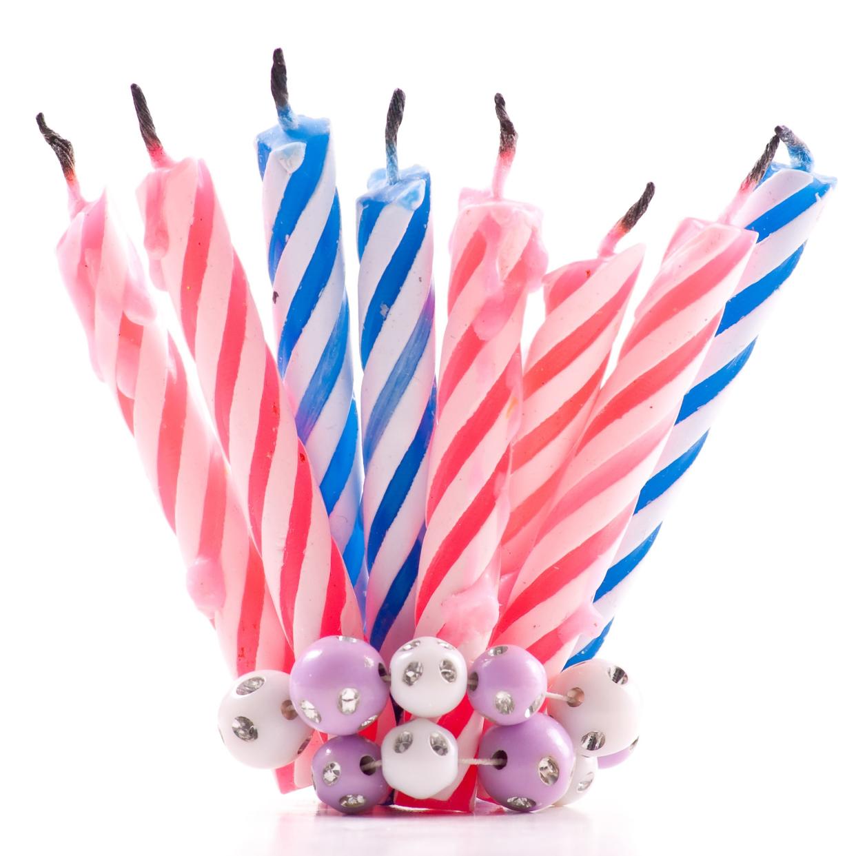 array of blue and pink birthday candles that have already been used