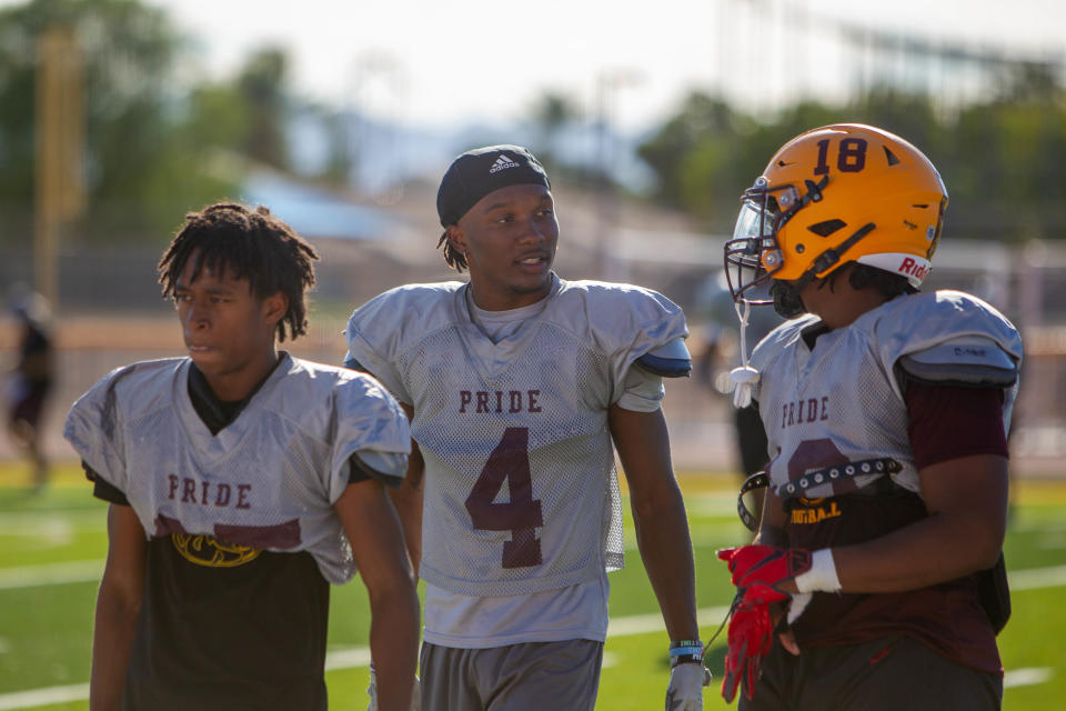 Rylon Dillard-Allen talks with teammates at Mountain Pointe high school football practice in Phoenix on Sept. 25, 2023.