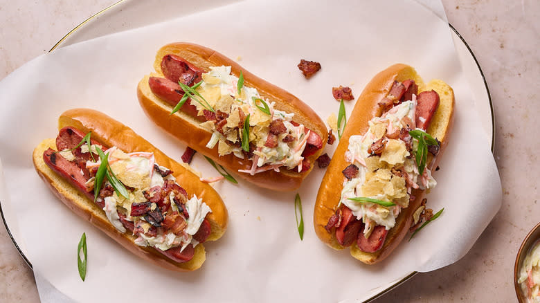 hot dogs with coleslaw, bacon and potato chips on platter