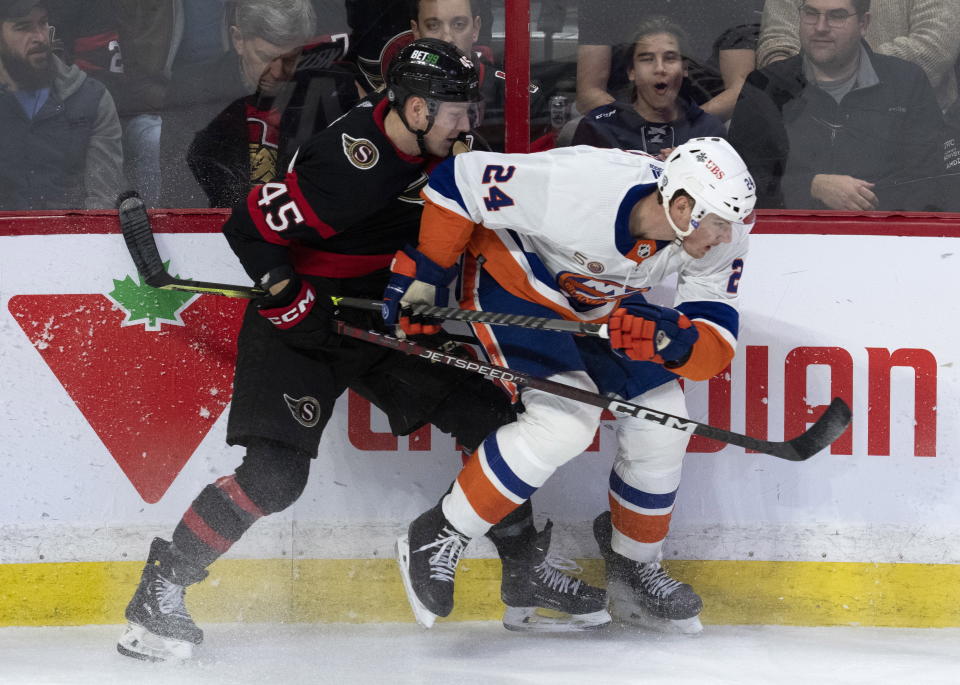 Ottawa Senators left wing Parker Kelly and New York Islanders defenseman Scott Mayfield collide along the boards during the first period of NHL hockey game, Wednesday, Jan. 25, 2023 in Ottawa, Ontario. (Adrian Wyld/The Canadian Press via AP)