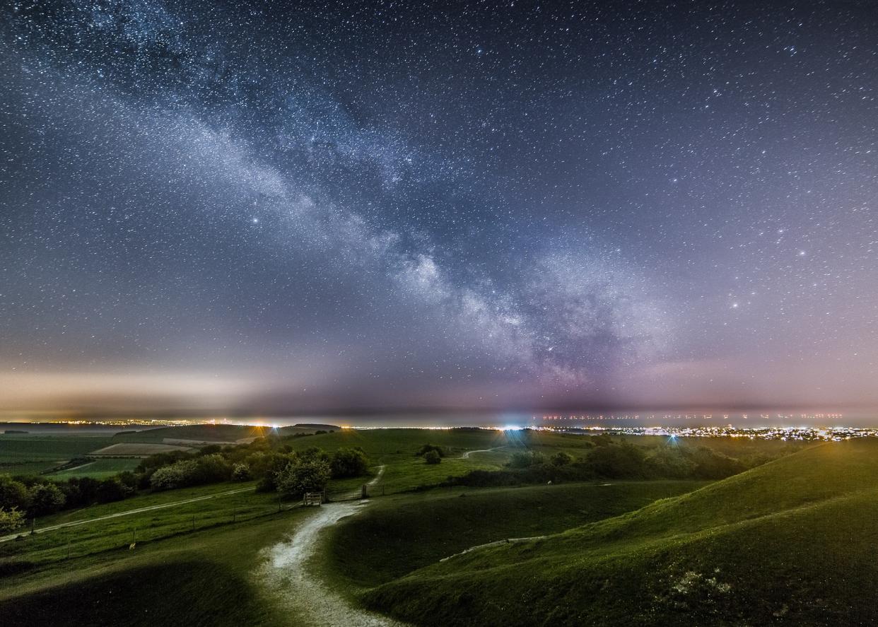 The Milky Way above the lights of Worthing and Brighton from Cissbury Ring with the lights of the Rampion Wind farm in the background by Neil Jones (Neil Jones/PA)