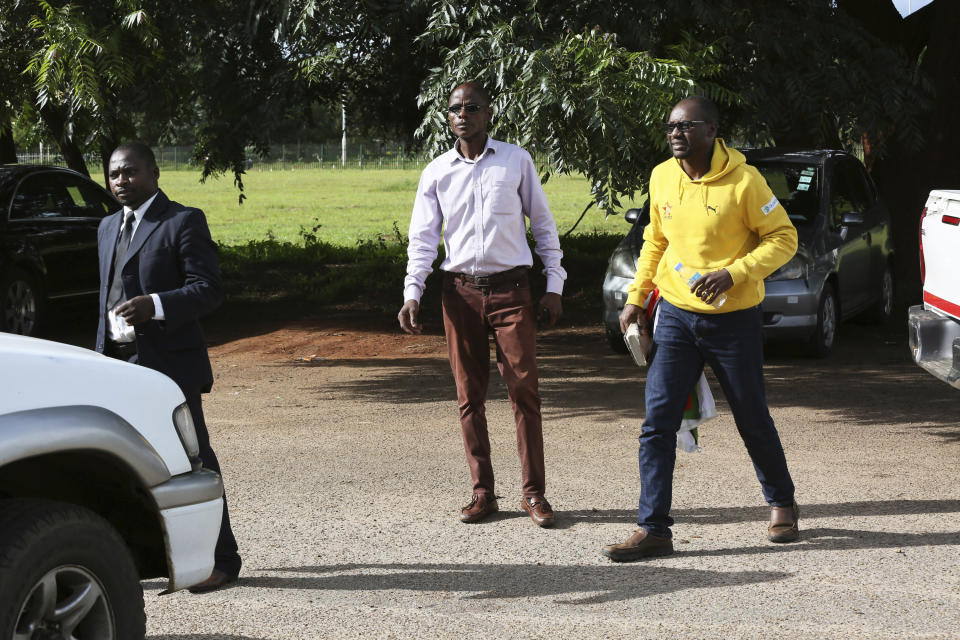 Pastor and activist Evan Mawarire, right, arrives at the magistrates courts in Harare, Zimbabwe, Thursday, Jan,17, 2019. A Zimbabwe Lawyers for Human Rights says in a statement that Mawarire who is among the more than 600 people arrested this week has been charged with subverting a constitutional government amid a crackdown on protests against a dramatic fuel price increase.(AP Photo/Tsvangirayi Mukwazhi)