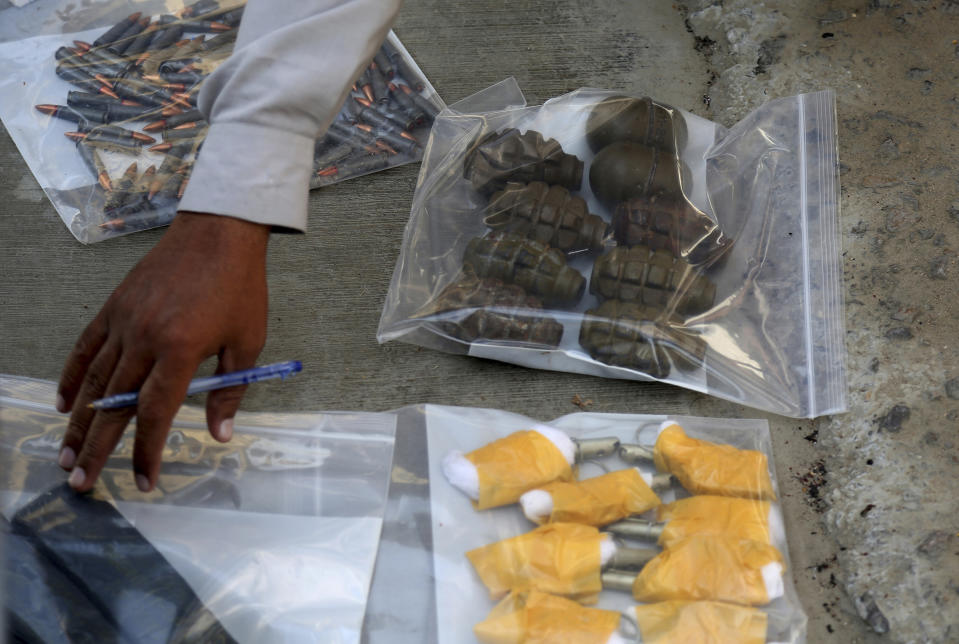An investigation officer checks ammunition recovered from an attack on the Chinese Consulate in Karachi, Pakistan, Friday, Nov. 23, 2018. Armed separatists stormed the Chinese Consulate in Pakistan's southern port city of Karachi on Friday, triggering an intense hour-long shootout during which two police officers and all three assailants were killed, Pakistani officials said. (AP Photo/Shakil Adil)