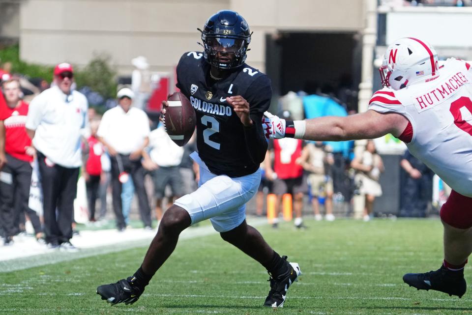 Colorado quarterback Shedeur Sanders (2) scrambles past Nebraska defensive lineman Nash Hutmacher in the fourth quarter at Folsom Field.