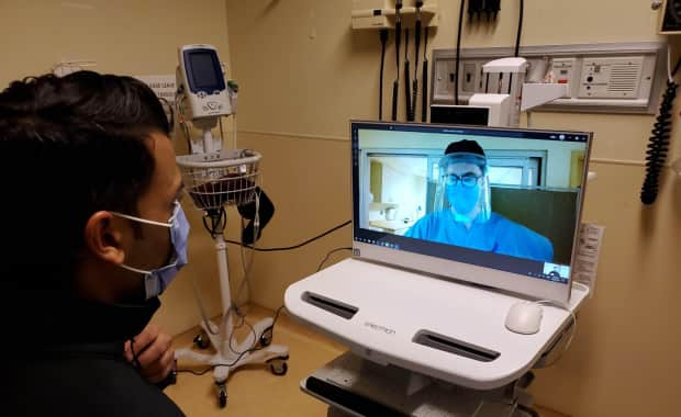 A virtual COVID-19 assessment room in Toronto General Hospital allows a doctor or nurse to asses a patient, hear their heart rate and read their blood pressure from a different room. (Supplied/University Health Network - image credit)