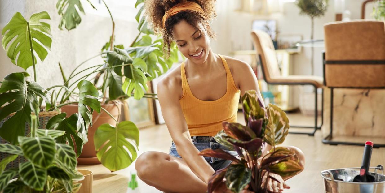 woman with curly hair planting in living room