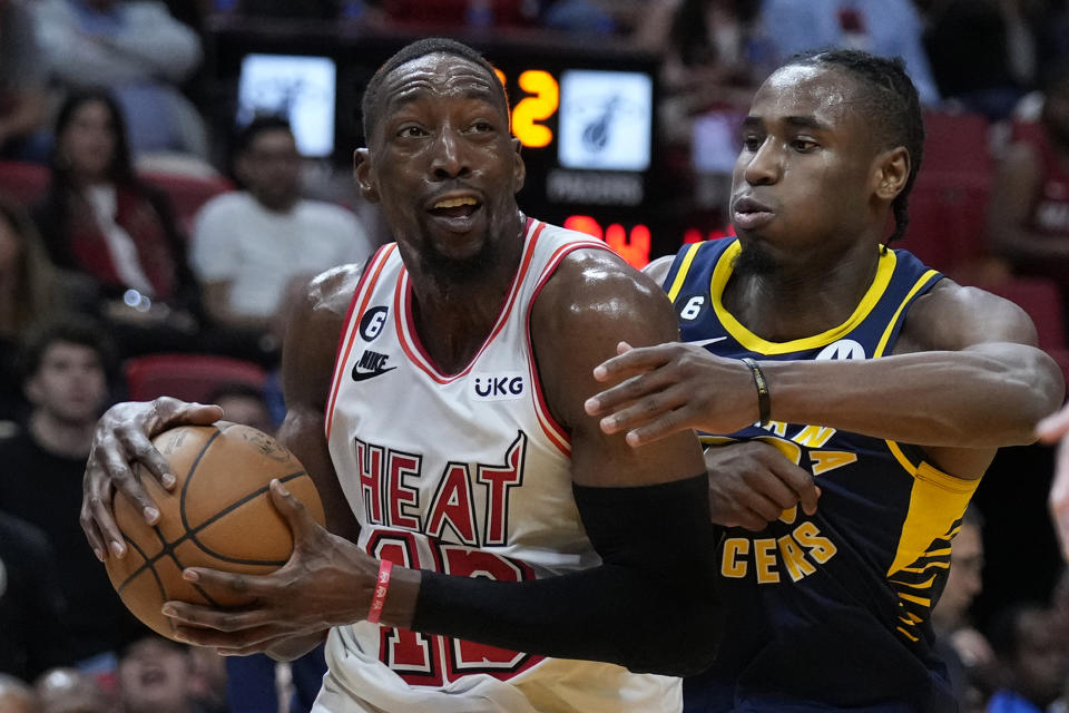 Miami Heat center Bam Adebayo, left, drives to the basket against Indiana Pacers guard Aaron Nesmith during the second half of an NBA basketball game, Wednesday, Feb. 8, 2023, in Miami. (AP Photo/Wilfredo Lee)