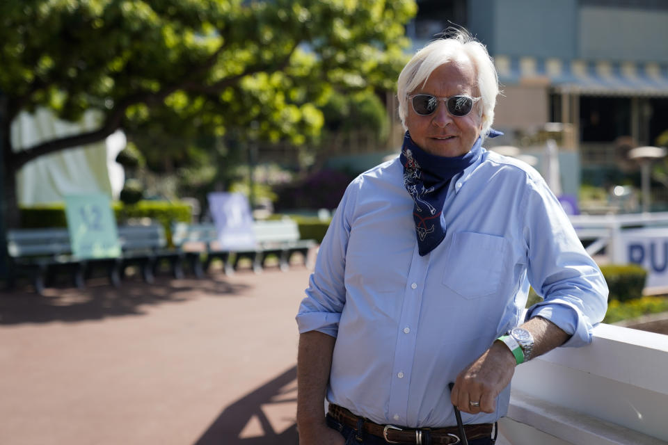 FILE - In this May 22, 2020, file photo, Bob Baffert, two-time Triple Crown-winning trainer, lowers his bandana during an interview while keeping his distance at Santa Anita Park in Arcadia, Calif. Baffert has been temporarily suspended from entering horses at New York racetracks pending an investigation into Kentucky Derby winner Medina Spirit. (AP Photo/Ashley Landis, File)