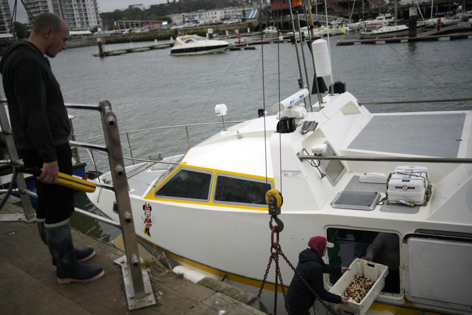 French fishermen empty their boat at the port of Boulogne-sur-Mer, northern France, Friday, Oct. 15, 202. France wants more fishing licenses from London, but the UK is holding back. Britain's Brexit minister accused the EU of wishing failure on its former member and of badmouthing the U.K. as a country that can't be trusted. (AP Photo/Christophe Ena)