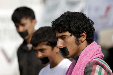 Migrants and refugees with their mouths taped stage a protest at a makeshift camp at the Greek-Macedonian border near the village of Idomeni, Greece, April 1, 2016. REUTERS/Marko Djurica