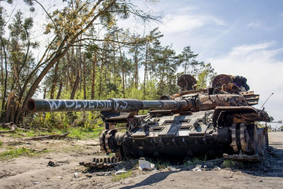 A destroyed Russian tank seen with graffiti on it in Kyiv Oblast.