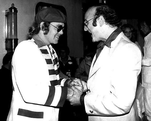 In 1976, Elton John (pictured left with music impresario Clive Davis) came out as bisexual in a Rolling Stone interview.