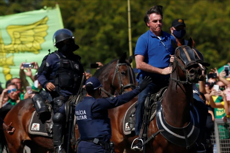 Brazil's President Jair Bolsonaro rides a horse during a meeting with supporters protesting in his favor, amid the coronavirus disease (COVID-19) outbreak, in Brasilia