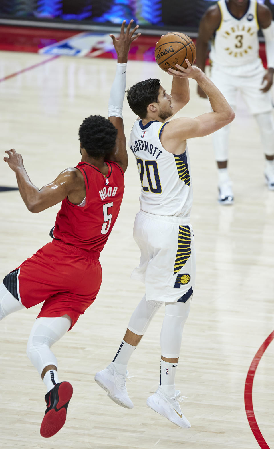 Indiana Pacers forward Doug McDermott, right, shoots a three-point basket in front of Portland Trail Blazers guard Rodney Hood during the first half of an NBA basketball game in Portland, Ore., Thursday, Jan. 14, 2021. (AP Photo/Craig Mitchelldyer)