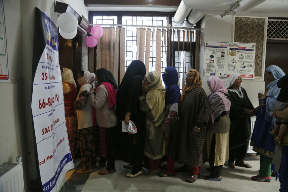 Kashmiri voters wait in a queue to cast their votes outside a poling station during the second phase of India's general elections, on the outskirts of Srinagar, Indian controlled Kashmir, Thursday, April 18, 2019. Kashmiri separatist leaders who challenge India's sovereignty over the disputed region have called for a boycott of the vote. Most polling stations in Srinagar and Budgam areas of Kashmir looked deserted in the morning with more armed police, paramilitary soldiers and election staff present than voters. (AP Photo/Mukhtar Khan)
