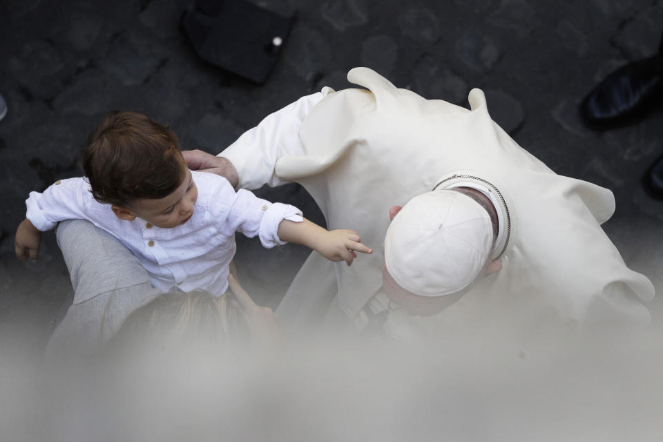 A child reaches out to Pope Francis as he greets faithful in the St. Damaso courtyard on the occasion of the weekly general audience at the Vatican, Wednesday, Sept. 16, 2020. (AP Photo/Gregorio Borgia)