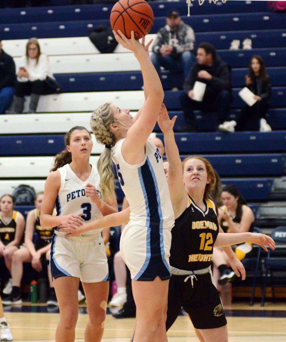 Petoskey's Sadie Corey finishes at the rim in front of an Ogemaw Heights defender Tuesday, with teammate Caitlyn Matelski watching on from behind.