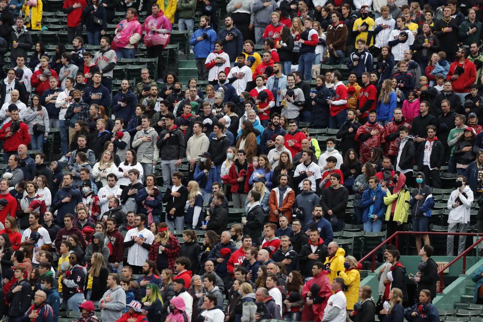 Fans stand for the national anthem before a baseball game between the Boston Red Sox and the Miami Marlins, Saturday, May 29, 2021, in Boston. Saturday marks the end of most COVID-19 restrictions in Massachusetts. (AP Photo/Michael Dwyer)