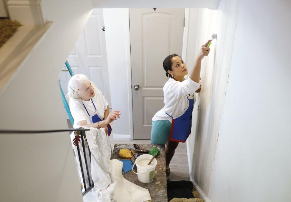 Reita Green, left, and Beverly Pate hang wallpaper at a client's home in Newhall.