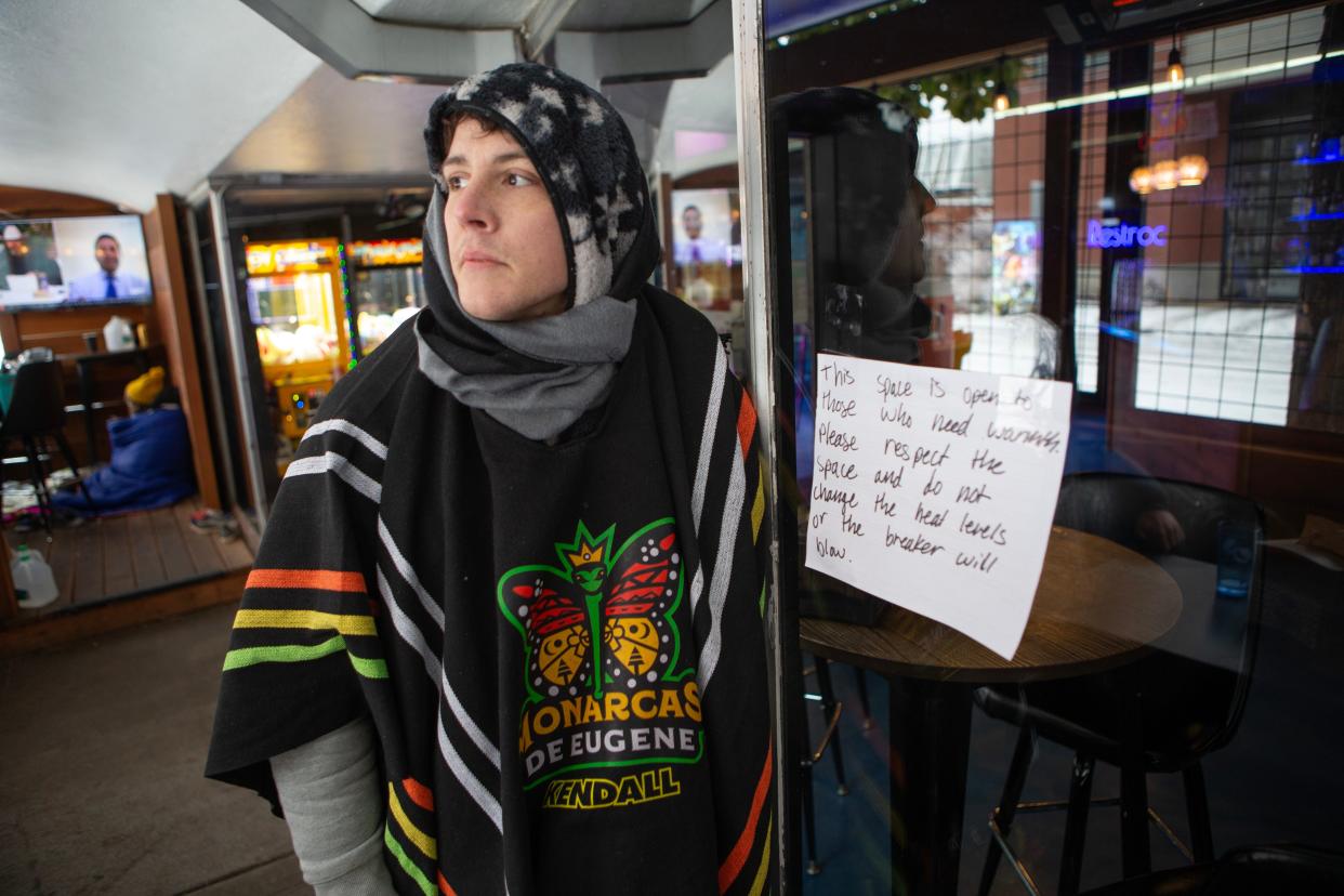 Joey King joins a dozen others sheltering from the cold on the porch of Big City Gamin' in Eugene after the owners welcomed them over the weekend as temperatures dipped below freezing.
