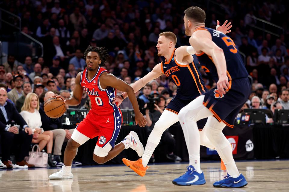 Philadelphia 76ers guard Tyrese Maxey, left, dribbles as the New York Knicks' Donte DiVincenzo (0) and Isaiah Hartenstein (55) during Game 2 of their first-round playoff series.