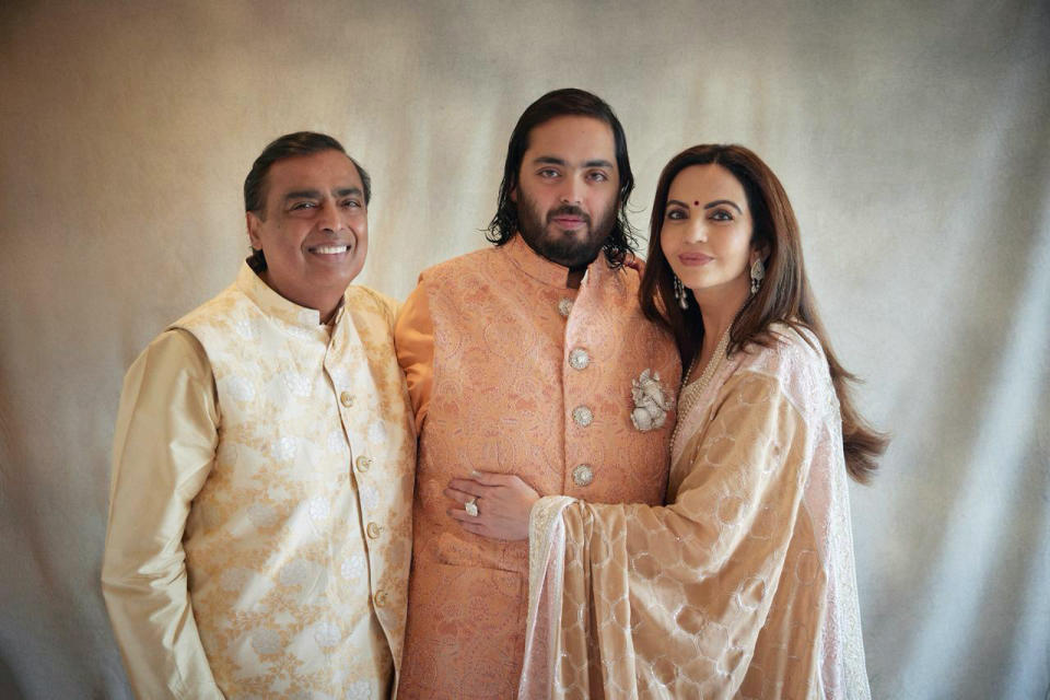 Esta fotografía publicada por el grupo Reliance muestra de izquierda a derecha al empresario multimillonario Mukesh Ambani, a su hijo Anant y a su esposa Nita, durante la celebración prenupcial del hijo menor del empresario indio, en Jamnagar, India, el sábado 2 de marzo de 2024. (Reliance group via AP)