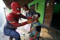 Man donning superhero costume brings cheer to children confined to their homes by COVID-19 restrictions in Sukoharjo